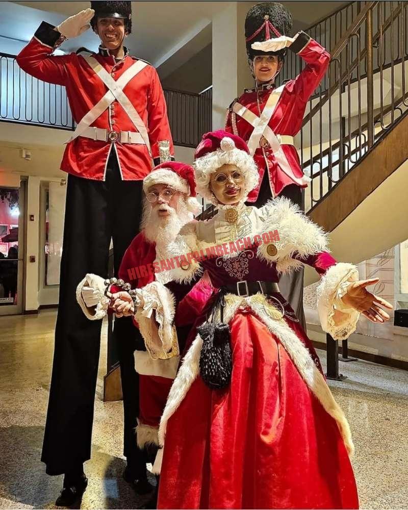 Corporate Santa for a company Christmas party: Santa, Mrs. Claus, and two stilt nutcrackers indoors.